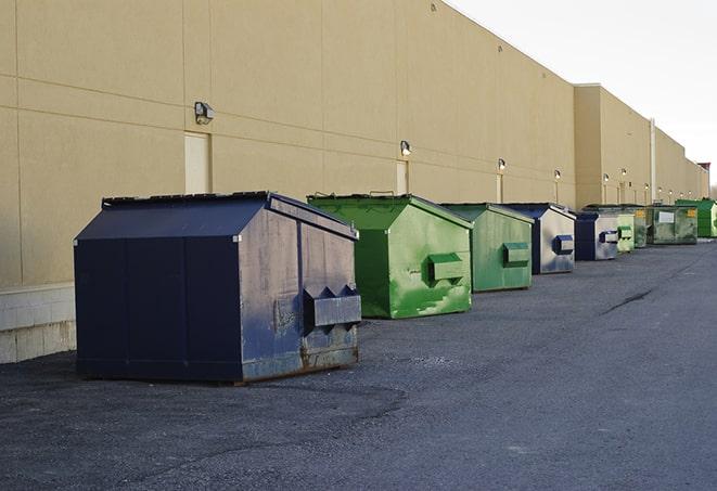 a waste management truck unloading into a construction dumpster in Daingerfield, TX